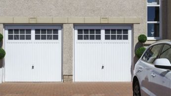 Double garage with white garage doors with windows